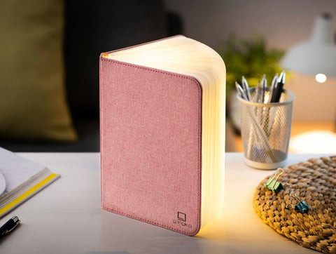 A clever concertina paged light which looks like a book. In linen texture  and blush pink colour. When closed, 9W x 12.2H x 2.5cm