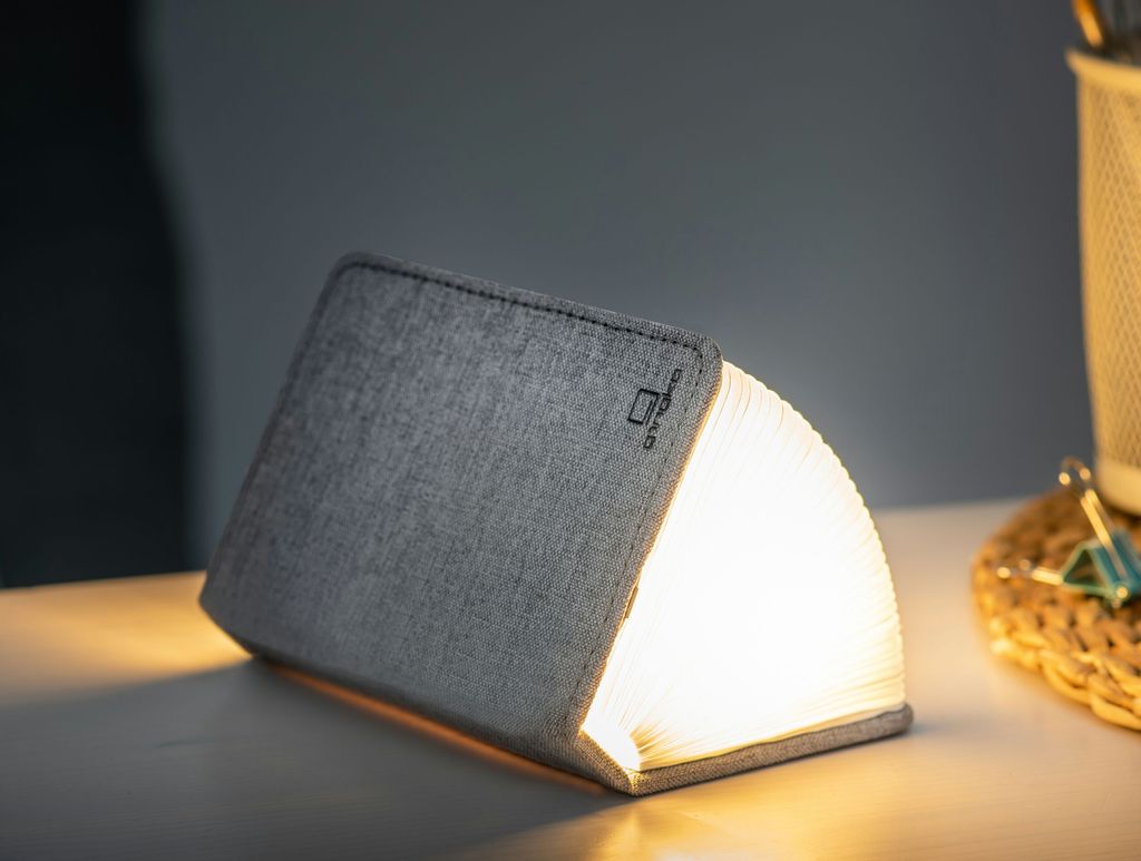 A clever concertina paged light which looks like a book in linen light grey. When closed, 9W x 12.2H x 2.5cm